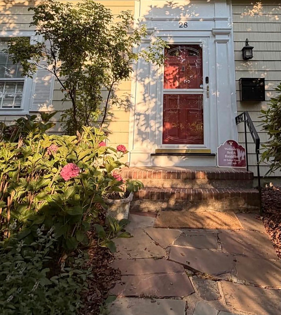 The front door and garden of Wellesley Boutique Inn, a bed and breakfast at 28 Eaton Court in Wellesley Hills, Massachusetts