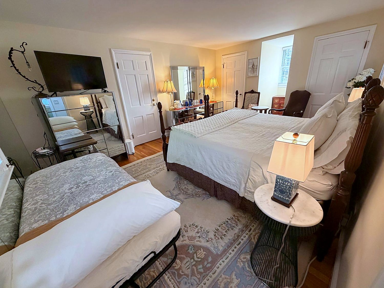 The larger room of the Two-Room Suite, with an additional bed, television and seating, at Wellesley Boutique Inn
